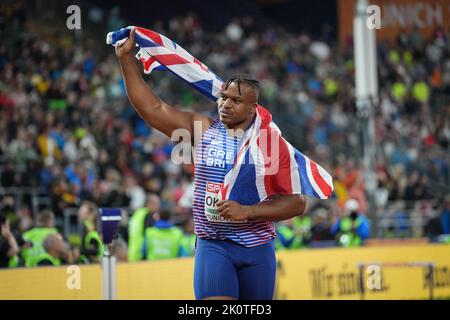 Lawrence Okoye con la bandiera del suo paese ai Campionati europei di atletica a Monaco di Baviera del 2022. Foto Stock