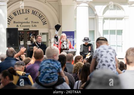 Il sindaco di Basingstoke, consigliere Paul Miller, alzando il cappello a una folla e facendo il tifo per l'adesione del re Carlo III al trono. Inghilterra Foto Stock