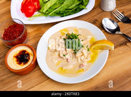 piyaz stile Antalya o insalata di fagioli con tahini e fetta d'arancia su piatto di porcellana bianca Foto Stock