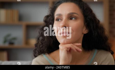 Indoor ritratto estremo primo piano faccia femminile con perfetta pelle make-up pensivo sognando pensieroso Ispanico 30s donna adulta ragazza a casa guarda Foto Stock