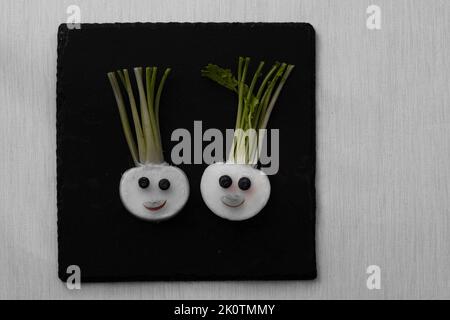 volti divertenti da blackberry e raddish, modo creativo sul piatto isolato Foto Stock