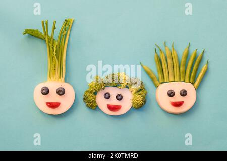 volti divertenti da mora, fagioli, broccoli e bianco raddish, modo creativo sulla piastra isolato Foto Stock