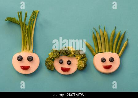 volti divertenti da mora, fagioli, broccoli e bianco raddish, modo creativo sulla piastra isolato Foto Stock