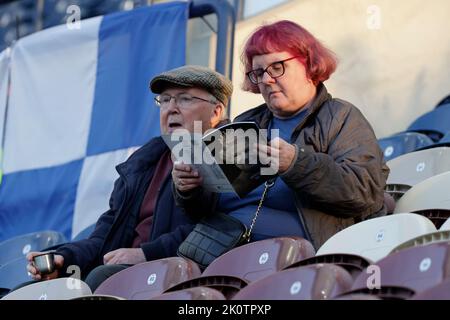 Una visione generale mentre i tifosi leggono il programma ufficiale del matchday che mostra la regina Elisabetta II davanti alla partita del campionato Sky Bet al Deepdale Stadium, Preston. Data immagine: Martedì 13 settembre 2022. Foto Stock