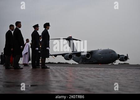 La festa della reception si ferma mentre il C-17 che porta la bara della Regina Elisabetta II arriva al Royal Air Force Northolt, Londra ovest, da dove sarà portato a Buckingham Palace, Londra, per riposare durante la notte nella sala Bow. Data immagine: Martedì 13 settembre 2022. Foto Stock