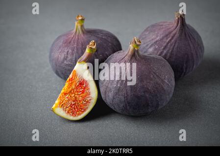 Fichi freschi su sfondo grigio. Bella frutta viola blu primo piano Foto Stock