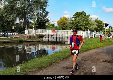 Andrew, runner n. 27 nella corsa sui canali a lunga distanza da Liverpool a Leeds, passa il ponte sospeso di Crabtree Lane mentre si apre per il passaggio di una barca sul canale Foto Stock