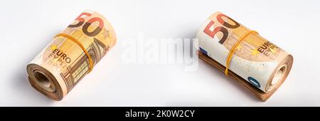 Rotolo di denaro. Rotolo di 50 banconote in euro. Le banconote in euro si sono arrotolate su uno sfondo grigio. Il concetto di assistenza finanziaria, acquisto immobiliare Foto Stock