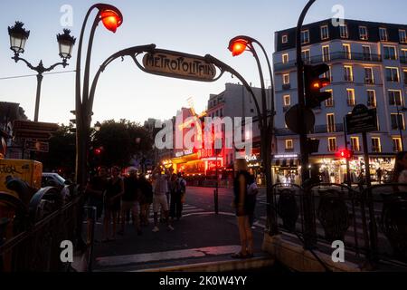 Parigi, Francia - Luglio, 15: Vista notturna della stazione metropolitana Metropolitan con decorazioni art nouveau con il Moulin Rouge sullo sfondo a Parigi su J Foto Stock