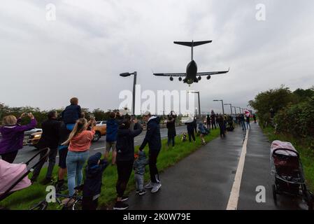 RAF Northolt, South Ruislip, Londra, Regno Unito. 13th Set, 2022. Il corpo della regina Elisabetta II è stato volato dall'aeroporto di Edimburgo dal Royal Air Force Boeing C-17A Globemaster III numero di serie ZZ177 ed è visto in finale per atterrare al RAF Northolt di Londra. La bara sarà quindi trasferita al trasporto su strada per il viaggio a Buckingham Palace. Il grande velivolo di trasporto atterrato sopra gli anni A40 e membri del pubblico che aveva sfidato la pioggia di sera. Persone che scattano fotografie con i telefoni cellulari Foto Stock