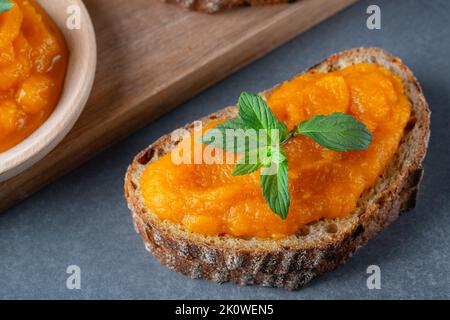 Sandwich con gustosa marmellata di zucca sul tavolo grigio Foto Stock