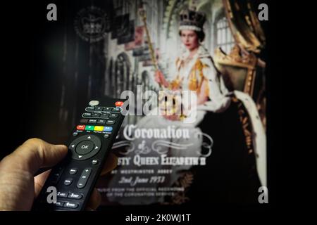 Belgrado, Serbia - 12 settembre 2022: Incoronazione della Regina Elisabetta II. Guardare un documentario sulla Regina d'Inghilterra in tv con telecomando in mano. Foto Stock