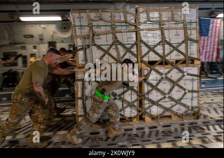 Chaklala, Pakistan. 09 Settembre 2022. Il personale militare degli Stati Uniti assegnato al comando centrale scarica le forniture di soccorso da un aereo da carico USAF C-130 a sostegno di una missione umanitaria USAID presso la base aerea del Pakistan Nur Khan, 9 settembre 2022 a Chaklala, provincia del Punjab, Pakistan. L'aeronautica ha cominciato trasportare 630 tonnellate metriche di rifornimenti di soccorso dopo che le inondazioni voluminose hanno devastato la nazione. Credito: SSgt. Charles Fultz/US Air Force Photo/Alamy Live News Foto Stock