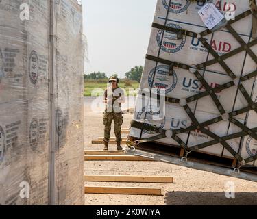 Sukkur, Pakistan. 11 Settembre 2022. Personale militare degli Stati Uniti assegnato al comando centrale di soccorso di guardia forniture scaricate da un aereo da carico C-130 USAF a sostegno di una missione umanitaria USAID per il Pakistan a Begum Nusrat Bhutto Airport, 11 settembre 2022 a Sukkur City, Pakistan. L'aeronautica ha cominciato trasportare 630 tonnellate metriche di rifornimenti di soccorso dopo che le inondazioni voluminose hanno devastato la nazione. Credito: TSgt. Isaac Garden/US Air Force Photo/Alamy Live News Foto Stock