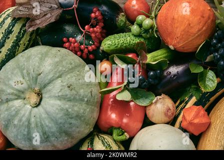 Verdure autunnali mature e bacche sono disposti sul tavolo. Vista dall'alto. Sfondo di fresco Vegets.The concetto di uno stile di vita sano. Foto Stock