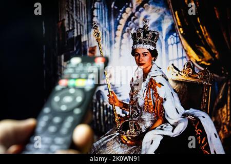 Belgrado, Serbia - 12 settembre 2022: Incoronazione della Regina Elisabetta II. Guardare un documentario sulla Regina d'Inghilterra in tv con telecomando in mano. Foto Stock