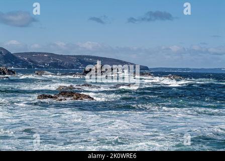 Acqua bianca creata mentre le onde dell'Oceano Atlantico si tuffano su un frangiflutti. Foto Stock