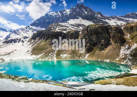 Lago di smeraldo alpino e montagne in primavera, Alpi del Gran Paradiso, Italia Foto Stock