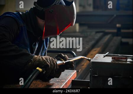 Taglio di una trave in acciaio con una torcia. Foto Stock