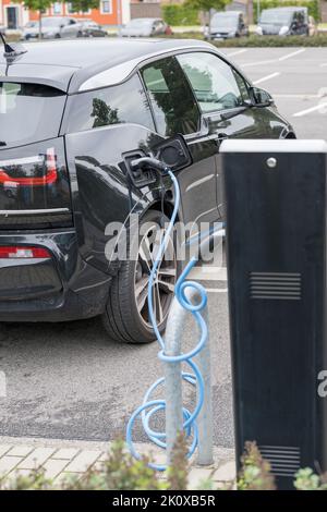 Un auto elettrica in corrispondenza di una stazione di carica Foto Stock