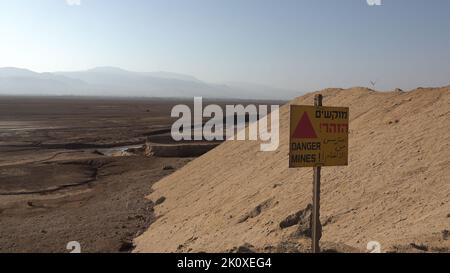 Un cartello di avvertimento posto sul sito di una barriera di sale lungo il confine con la Giordania il 13 settembre 2022, nel Mar Morto, Israele. L'esercito israeliano sta costruendo un progetto unico di una barriera di sale naturale a sud dell'insediamento israeliano di Neot HaKikar nella zona meridionale del Mar Morto, la parete di sale estratta dal Mar Morto raggiungerà un'altezza massima di 13 metri (42 piedi) per 40 km (24 miglia) E renderà difficile per gli infiltrati attraversare il confine dalla Giordania. Foto Stock