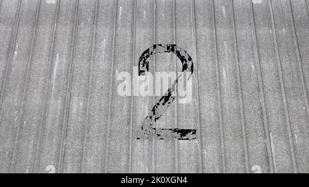 il numero due è stato alterato e dipinto su una parete del magazzino Foto Stock