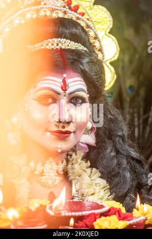Agomoni Concept Photo Shoot, viso donna con trucco perfetto come la dea dietro fiamma. Foto Stock