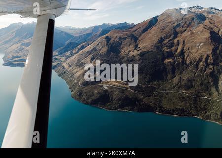 Una strada si snoda intorno al Lago Wakatipu vicino a Queenstown, Nuova Zelanda Foto Stock