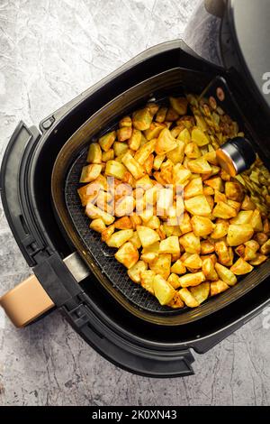 Patate fatte in casa in friggitrice ad aria, un modo sano per cucinare cibi fritti Foto Stock