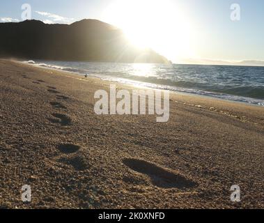impronte e la spiaggia al tramonto Foto Stock