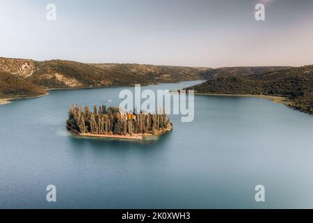 Veduta aerea del Monastero di Visovac, situato nel Parco Nazionale di Krka e costruito sopra le antiche catacombe romane. Piccola isola nel mezzo del fiume. Foto Stock