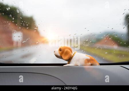 Bambola marrone cane cucciolo che scuote la testa annuita in auto Foto Stock