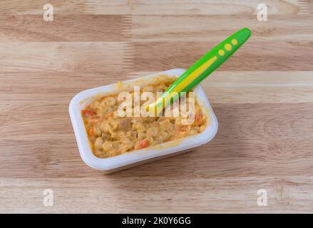 Maccheroni e pappe al formaggio con un cucchiaio di pappe su un tavolo in legno illuminato da luce naturale. Foto Stock