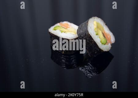 due pezzi di sushi su sfondo scuro Foto Stock