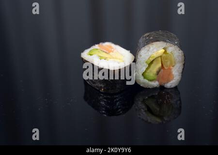 due pezzi di sushi su sfondo scuro Foto Stock