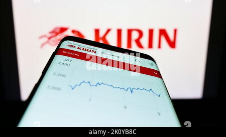 Telefono cellulare con pagina Web della Kirin Brewery Company Limited giapponese sullo schermo di fronte al logo aziendale. Messa a fuoco in alto a sinistra del display del telefono. Foto Stock