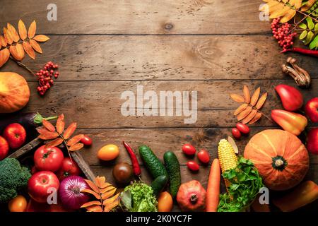 Sfondo frutta verdura raccolta autunno. Sfondo rustico in legno e cornice fatta di prodotti vegetariani freschi per un sano pasto del Ringraziamento. Foto Stock