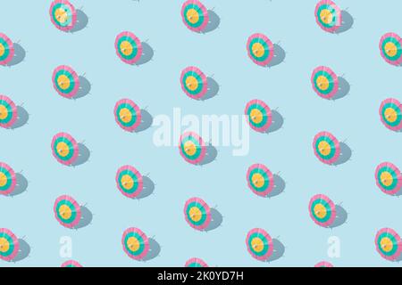 Modello estivo - ombrelli da cocktail di carta su sfondo blu. Concetto minimo. Foto Stock