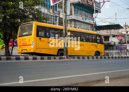 Aprile 13th 2022, Dehradun City Uttarakhand India. Un grande autobus giallo DIT University che trasporta studenti sulle strade della città di dehradun Foto Stock