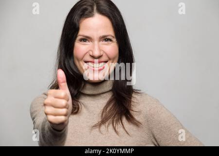 ritratto di una donna anziana sorridente che mostra un gesto di pollice in su Foto Stock