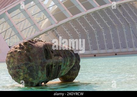 Faccia la scultura della testa di Igor Mitoraj di fronte al dettaglio dell'edificio Hemisfèric alla Città delle Arti e delle Scienze di Valencia, Spagna nel mese di settembre Foto Stock