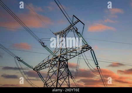 Overhead transmission line tower against sunset sky, detail. Foto Stock