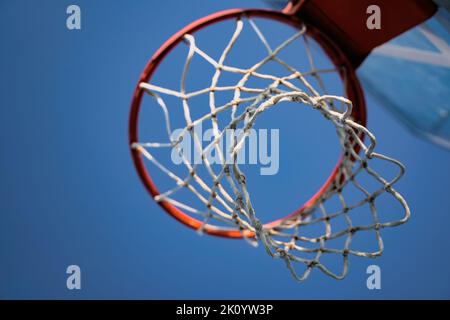 primo piano di basket all'aperto rete di corda bianca vista da sotto contro un cielo blu con copyspace Foto Stock