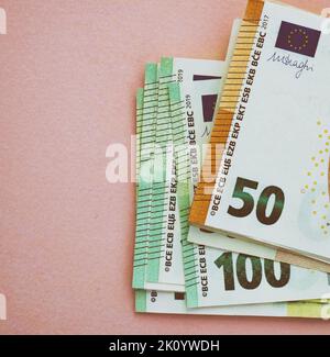 Confezione di banconote in euro su sfondo rosa. Valuta europea, affari, finanza. 50 e 100 euro Foto Stock