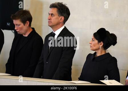 Ed Miliband (al centro) e Priti Patel (a destra) osservano come il partito portatore trasporta la bara della regina Elisabetta II nella Westminster Hall, Londra, dove si trova in stato davanti al suo funerale il lunedì. Data immagine: Mercoledì 14 settembre 2022. Foto Stock