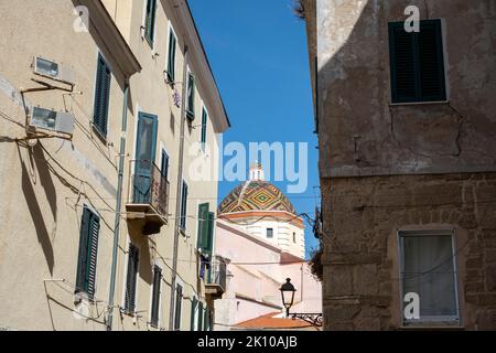 Vista della cupola colorata della chiesa barocca di San Michele sullo skyline del centro storico di Alghero, Sardegna, Italia Foto Stock