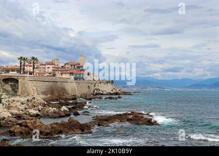Una vista in lontananza della città costiera di Antibes, mostrando la città vecchia racchiusa da bastioni del 16th ° secolo che si innalzano sopra il mare. Costa Azzurra. Foto Stock