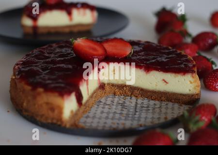 Fetta di torta al formaggio Strawberry. Torta al formaggio cremosa e liscia con salsa di fragole fresca fatta in casa. Sparare con fragole fresche intorno Foto Stock