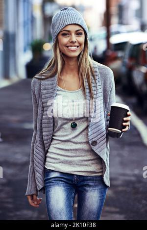 Che bella mattina in città. Ritratto di una bella giovane donna che cammina con un caffè da asporto in città. Foto Stock