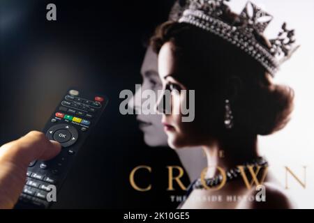 Belgrado, Serbia - 12 settembre 2022: Guardare la TV Show la corona su Netflix con telecomando in mano. La serie TV è circa la famiglia reale britannica e. Foto Stock